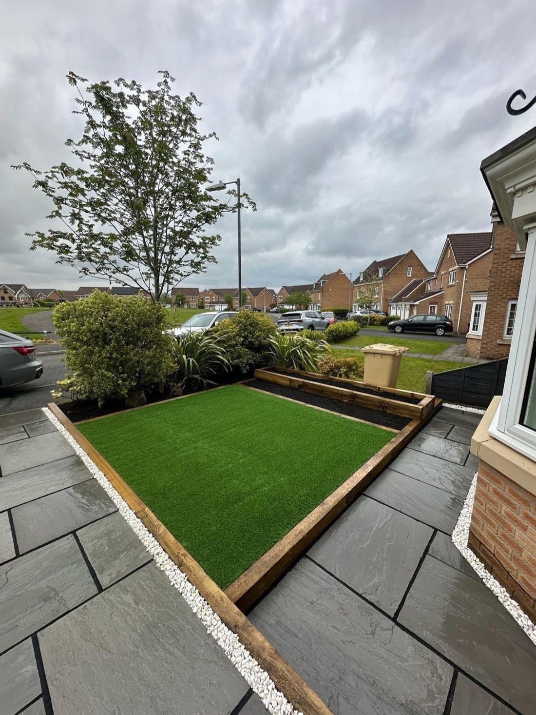 Dominic's front garden with artificial grass framed by sleepers and new paving