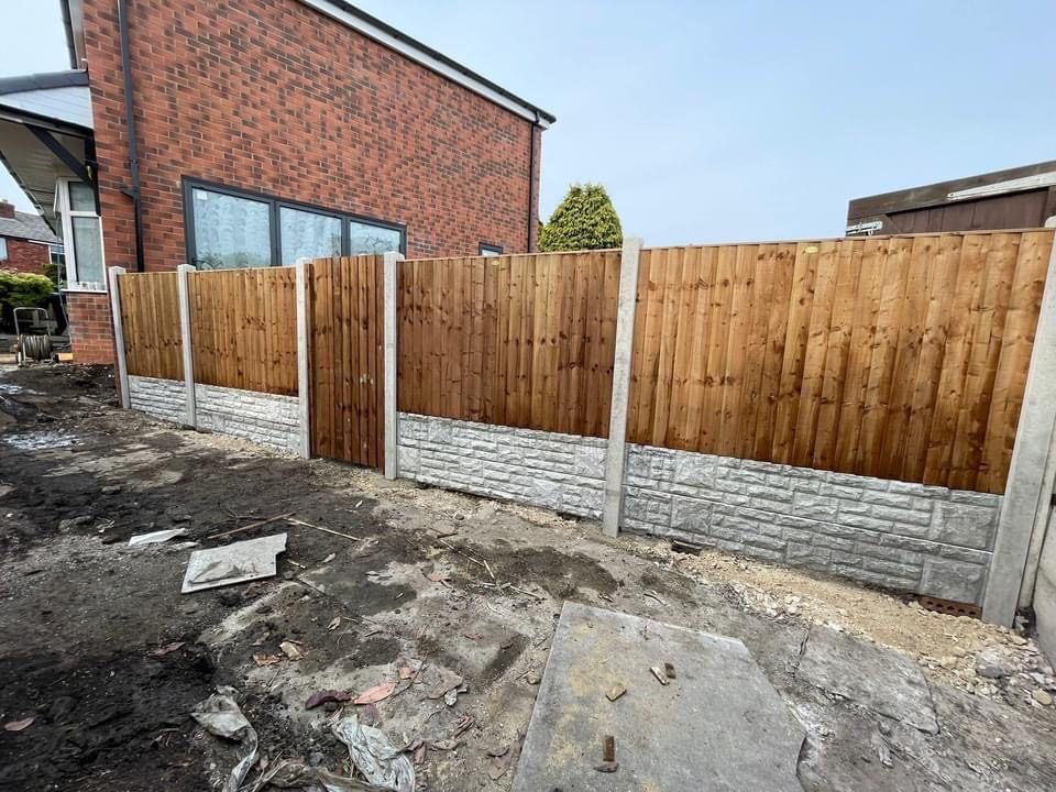 Fence posts being set in concrete during installation in Bolton