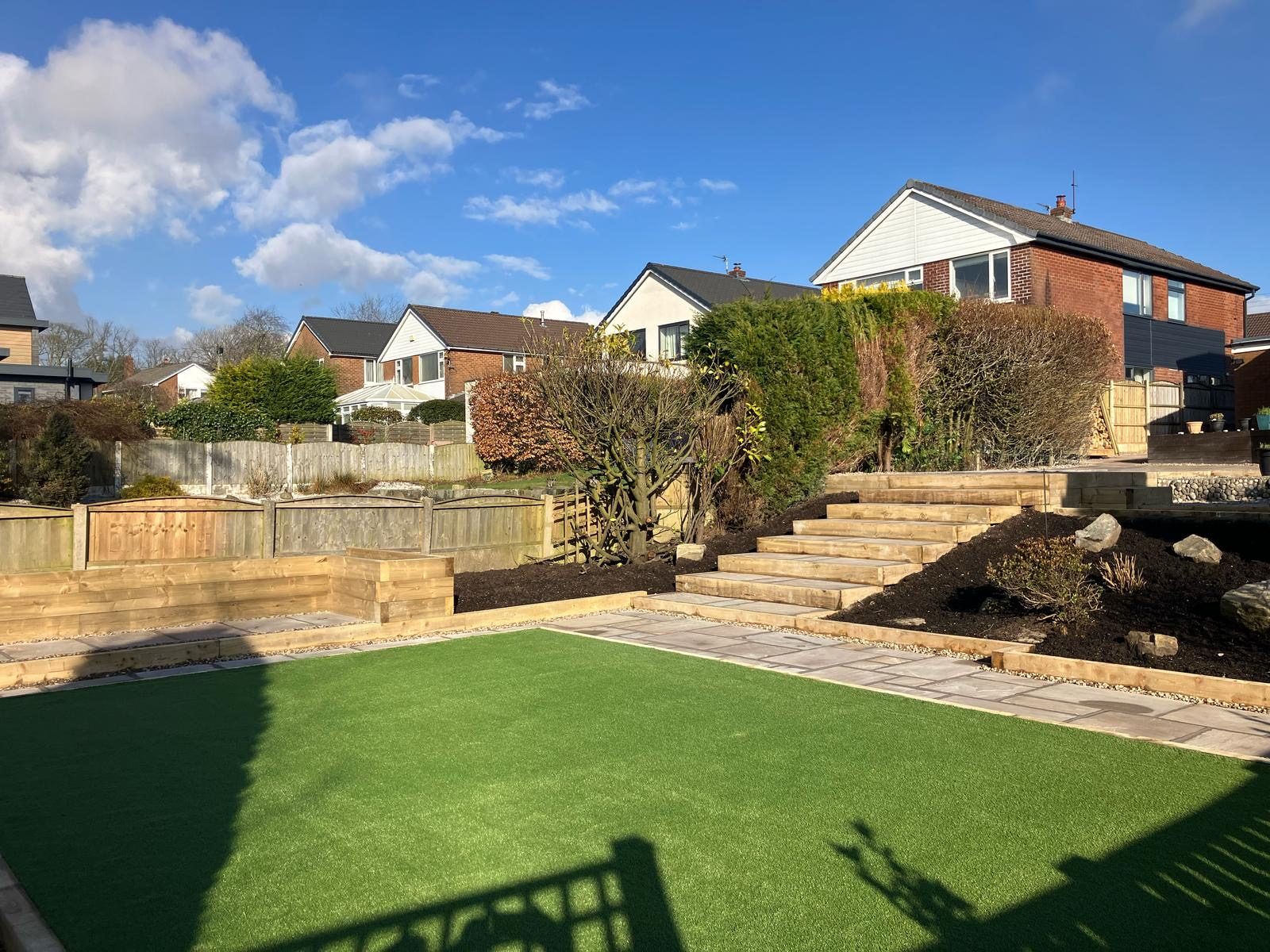 Freshly laid artificial grass lawn with steps in a Bolton garden