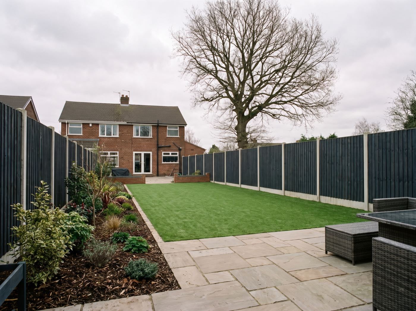 Finished back garden in Wigan after landscaping, with a new patio, lawn and fence (illustrative)