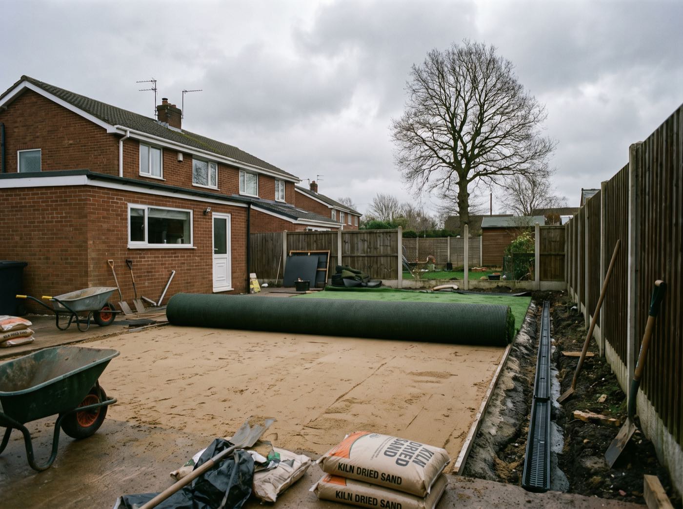 Artificial grass being fitted in a Wigan back garden (illustrative)
