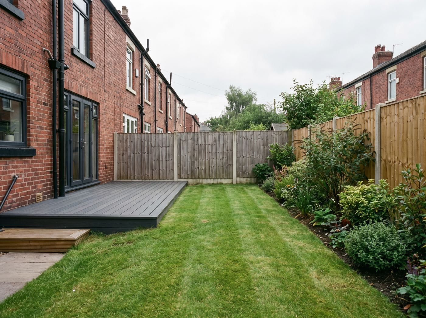 Finished back garden in Manchester after landscaping, with a new patio, lawn and fence (illustrative)