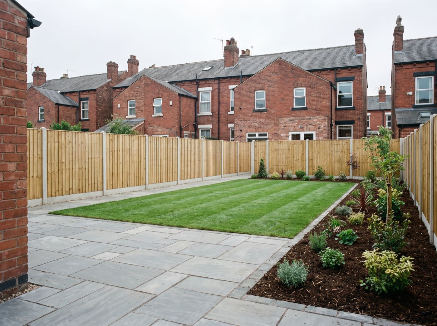 Finished back garden in Manchester after landscaping, with a new patio, lawn and fence (illustrative)