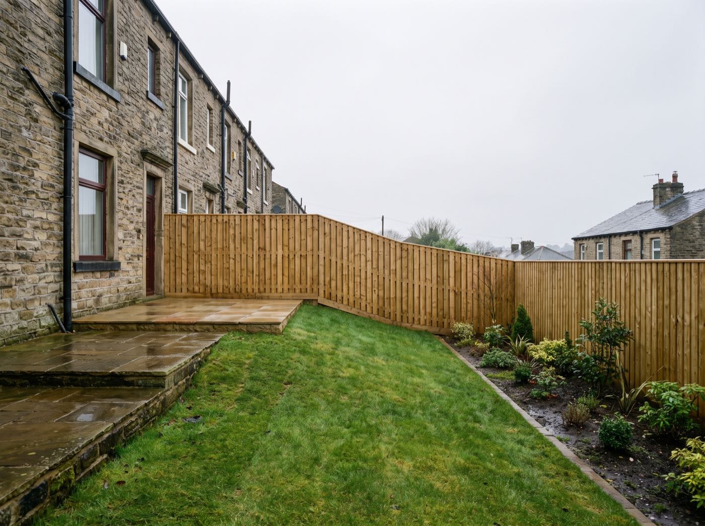 Finished back garden in Oldham after landscaping, with a new patio, lawn and fence (illustrative)