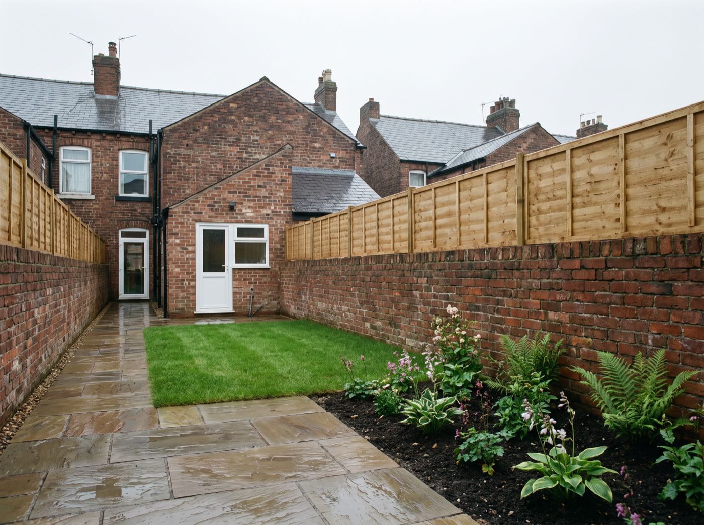 Finished back garden in Salford after landscaping, with a new patio, lawn and fence (illustrative)