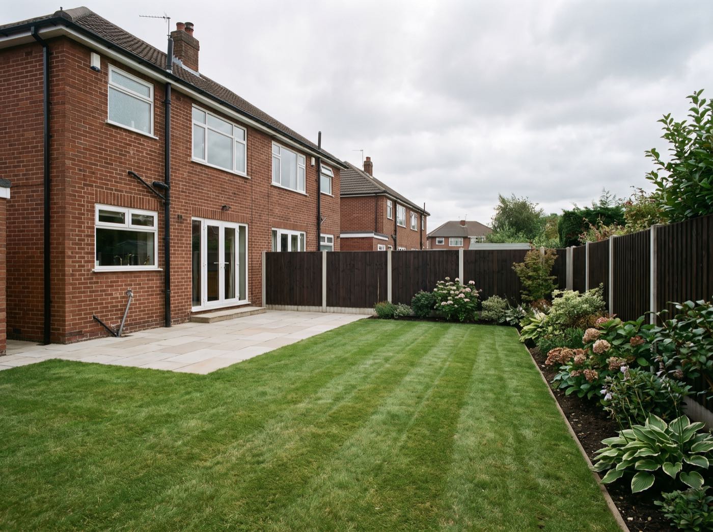 Finished back garden in Breightmet after landscaping, with a new patio, lawn and fence (illustrative)