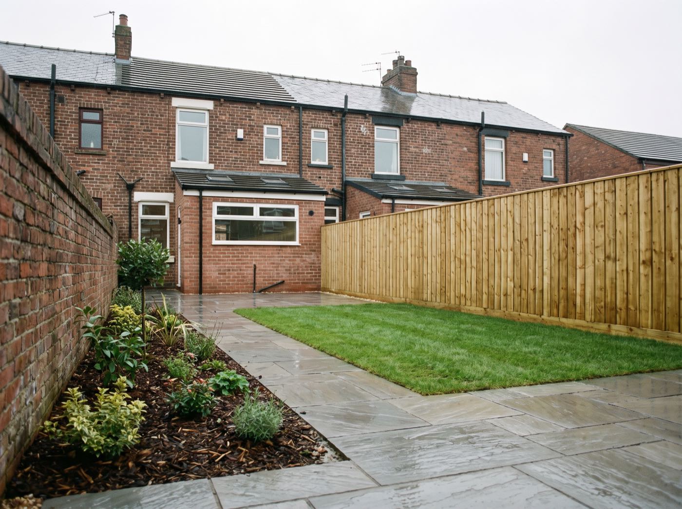 Finished back garden in Farnworth after landscaping, with a new patio, lawn and fence (illustrative)