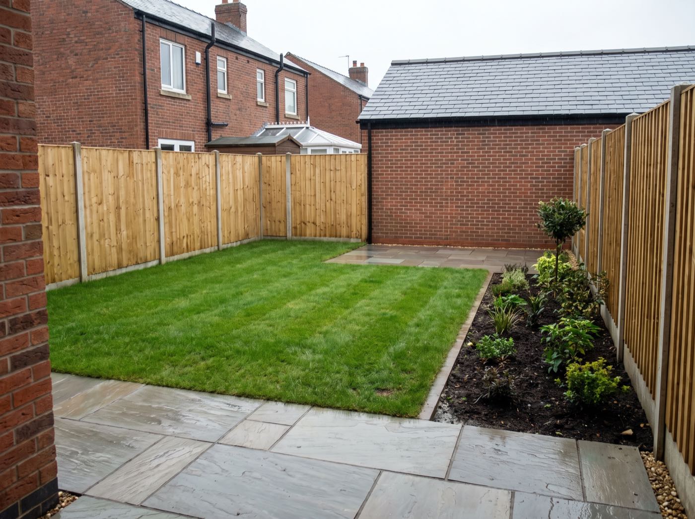 Finished back garden in Hindley after landscaping, with a new patio, lawn and fence (illustrative)