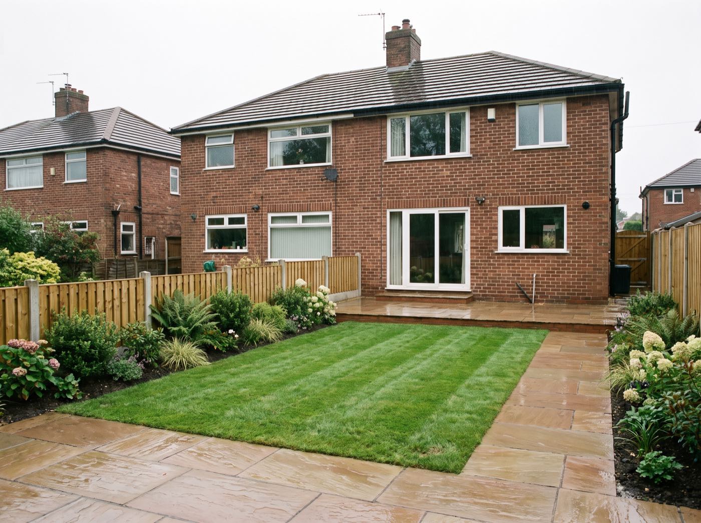 Finished back garden in Markland Hill after landscaping, with a new patio, lawn and fence (illustrative)