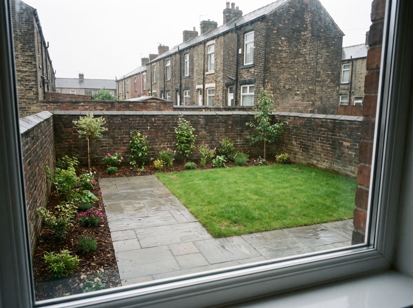 Finished back garden in Tonge Moor after landscaping, with a new patio, lawn and fence (illustrative)