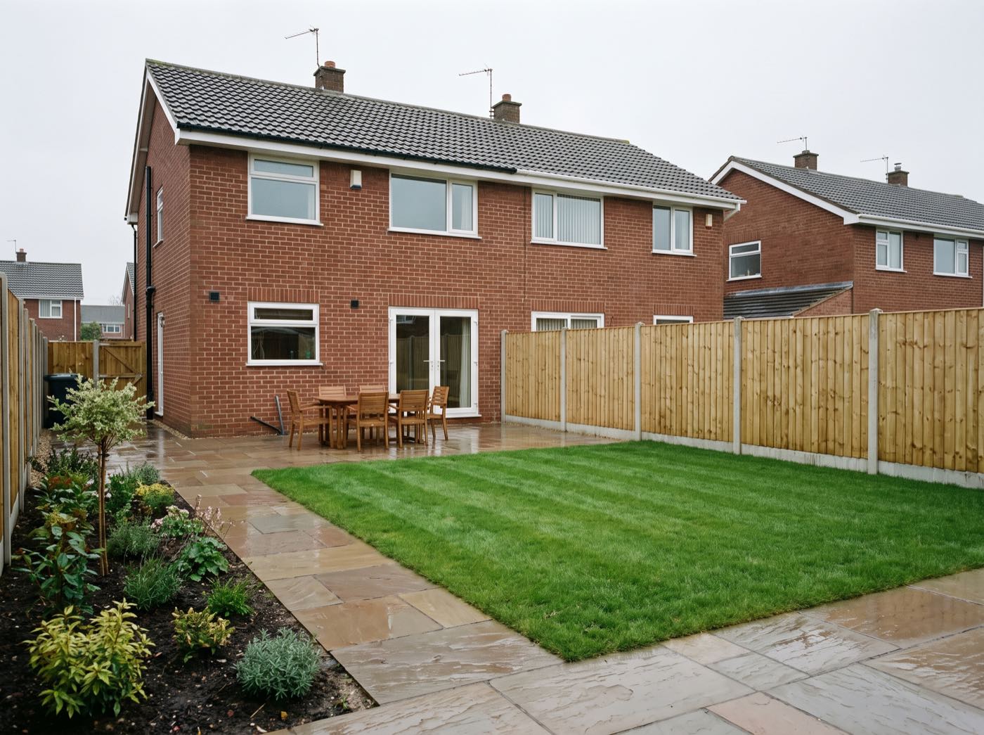 Finished back garden in Westhoughton after landscaping, with a new patio, lawn and fence (illustrative)